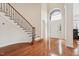 Bright foyer featuring hardwood floors, an arched window, and a staircase leading to the upper level at 7 Teahouse Ct, Durham, NC 27707