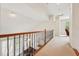 Hallway with hardwood railing, carpet and view of Gathering room below at 7 Teahouse Ct, Durham, NC 27707