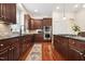 Well-equipped kitchen features dark wood cabinets, stainless appliances, black granite countertops and hardwood flooring at 7 Teahouse Ct, Durham, NC 27707