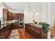 Modern kitchen with dark cabinetry, stainless steel appliances, hardwood floors, and granite countertops at 7 Teahouse Ct, Durham, NC 27707