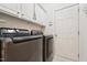 This modern laundry room features front loading washer and dryer and storage cabinets at 7 Teahouse Ct, Durham, NC 27707