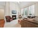Cozy living room with vaulted ceilings, a fireplace, built-in shelving, and large windows with sheer curtains at 7 Teahouse Ct, Durham, NC 27707