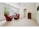 Bright, carpeted living room featuring windows, ceiling fan and two arm chairs at 7 Teahouse Ct, Durham, NC 27707