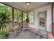 Comfortable screened-in porch with rocking chairs, a ceiling fan, and access to the backyard at 7 Teahouse Ct, Durham, NC 27707