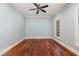 Bright bedroom with hardwood floors, ceiling fan, and natural light from large windows at 7604 Copper Creek Ct, Wake Forest, NC 27587