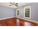 This bedroom features hardwood floors, two windows, a ceiling fan, and neutral paint at 7604 Copper Creek Ct, Wake Forest, NC 27587