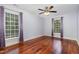 Bedroom with wood floors, ceiling fan, two windows with shades and violet curtains at 7604 Copper Creek Ct, Wake Forest, NC 27587