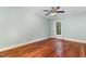 A bedroom with hardwood floors, a ceiling fan, and a large window at 7604 Copper Creek Ct, Wake Forest, NC 27587