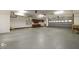 Large three car garage with attached cabinetry, grey flooring and access door at 7604 Copper Creek Ct, Wake Forest, NC 27587