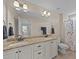 Elegant bathroom featuring a double vanity with granite countertops and ample lighting, complemented by a tiled shower at 80 Shallow Falls Ln, Benson, NC 27504