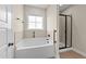 Bright bathroom with soaking tub, shower, and tiled floors at 80 Shallow Falls Ln, Benson, NC 27504