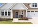 Charming covered front porch featuring a cozy bench and a vibrant floral wreath on the front door at 80 Shallow Falls Ln, Benson, NC 27504