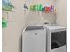 Well-organized laundry room with modern white washer and dryer, plus ample shelving for storage and organization at 80 Shallow Falls Ln, Benson, NC 27504