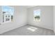 This empty bedroom features two windows offering plenty of natural light, carpet, and neutral paint at 800 Hillfarm Dr, Wake Forest, NC 27587