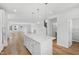 Open-concept kitchen with white cabinetry, quartz island, stainless appliances, and seamless flow into the spacious living area at 800 Hillfarm Dr, Wake Forest, NC 27587