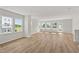 Bright living room featuring gleaming hardwood floors, multiple windows offering abundant natural light, and neutral paint at 800 Hillfarm Dr, Wake Forest, NC 27587