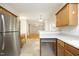 Kitchen featuring a stainless steel dishwasher, light wood cabinets, and open layout at 803 High Ct, Hillsborough, NC 27278