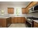 Kitchen featuring stainless steel appliances, wood cabinets, and a window overlooking the backyard at 803 High Ct, Hillsborough, NC 27278