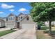 Exterior view of townhome with attached garage, showcasing manicured front lawn and complemented by mature trees at 8111 Yaxley Hall Dr, Raleigh, NC 27616