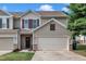 Charming townhome with a two-car garage, neat lawn, and inviting front entrance with brick and black door at 8111 Yaxley Hall Dr, Raleigh, NC 27616