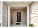 Inviting front entrance featuring brick accents, a wreath-adorned door, and a charming 'Home' sign, adding a welcoming touch at 8111 Yaxley Hall Dr, Raleigh, NC 27616