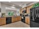 Modern kitchen showcasing black appliances, light wood cabinetry, and an open view to the dining room at 8111 Yaxley Hall Dr, Raleigh, NC 27616