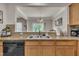 Bright kitchen sink and countertop area featuring light wood cabinetry with black appliances at 8111 Yaxley Hall Dr, Raleigh, NC 27616