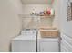This well-lit laundry room features a modern washer and dryer, and ample storage on the wire shelving above at 8111 Yaxley Hall Dr, Raleigh, NC 27616