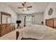 This main bedroom has carpeted floors, is illuminated by a ceiling fan, and features dark-wood furniture at 8111 Yaxley Hall Dr, Raleigh, NC 27616
