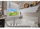 Bright bathroom featuring a soaking tub with a view, elegant chandelier, and stylish decor on a shelf at 814 Covered Bridge Trl, Chapel Hill, NC 27517