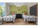 Bright bedroom features two beds, wood floor, green accent wall and nature inspired decor at 814 Covered Bridge Trl, Chapel Hill, NC 27517