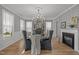 Elegant dining room with stylish lighting, fireplace, large windows, wainscoting and designer wallpaper at 814 Covered Bridge Trl, Chapel Hill, NC 27517