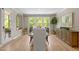 Bright dining area with large windows, wood floors, wooden cabinet and decorative mirror on the wall at 814 Covered Bridge Trl, Chapel Hill, NC 27517