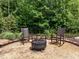 Backyard fire pit with rocking chairs; enjoy the outdoor relaxation and wooded privacy in the landscaped yard at 814 Covered Bridge Trl, Chapel Hill, NC 27517