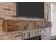Close up of brick fireplace with wood mantle and large television at 814 Covered Bridge Trl, Chapel Hill, NC 27517