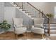 Close up on foyer with staircase, decorative wallpaper, hardwood floors and elegant seating area at 814 Covered Bridge Trl, Chapel Hill, NC 27517
