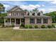 Charming brick home featuring manicured landscaping, a cozy front porch, and dormer windows at 814 Covered Bridge Trl, Chapel Hill, NC 27517
