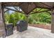 Well-equipped gazebo with a grill, a trash can and a serene view of the manicured backyard at 814 Covered Bridge Trl, Chapel Hill, NC 27517