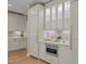 Kitchen area featuring white cabinetry, tiled backsplash, built-in stainless steel microwave, and hardwood floors at 814 Covered Bridge Trl, Chapel Hill, NC 27517