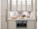 Kitchenette featuring a coffee station, mosaic backsplash and stainless steel microwave at 814 Covered Bridge Trl, Chapel Hill, NC 27517