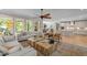 Spacious living room featuring a ceiling fan, large windows, hardwood floors, and an open view to the kitchen at 814 Covered Bridge Trl, Chapel Hill, NC 27517