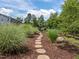 Stone path leading to a wooded backyard with a fire pit, inviting relaxation and entertainment at 814 Covered Bridge Trl, Chapel Hill, NC 27517
