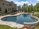 Relaxing pool with sun loungers, outdoor seating, stone accents, and a gazebo in the landscaped backyard at 814 Covered Bridge Trl, Chapel Hill, NC 27517