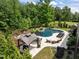 Stunning backyard pool with luxurious lounge area, gazebo, and mature landscaping for privacy at 814 Covered Bridge Trl, Chapel Hill, NC 27517