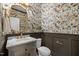 Cozy powder room features floral wallpaper, marble countertop and golden hardware fixtures at 814 Covered Bridge Trl, Chapel Hill, NC 27517