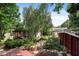 Landscaped backyard featuring a deck, mature trees, stream, and a play structure at 821 Woodburn Rd, Raleigh, NC 27605