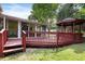 Outdoor deck with a gazebo and a view of the landscaped backyard with mature trees at 821 Woodburn Rd, Raleigh, NC 27605