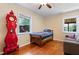 Bedroom features a bed, red clock, and hardwood floors at 821 Woodburn Rd, Raleigh, NC 27605