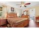 Well-lit bedroom features a ceiling fan, wood floors, and paneled wood bed frame at 821 Woodburn Rd, Raleigh, NC 27605