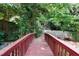 Charming footbridge leading to a cozy deck surrounded by lush greenery creates a peaceful outdoor retreat at 821 Woodburn Rd, Raleigh, NC 27605